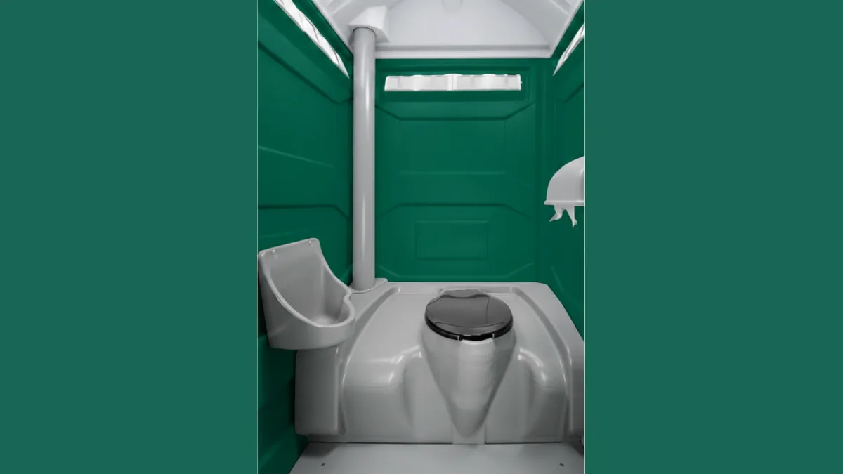 Interior of a PremierPlus portable toilet hire unit with flushing toilet, urinal and hand sanitiser dispenser